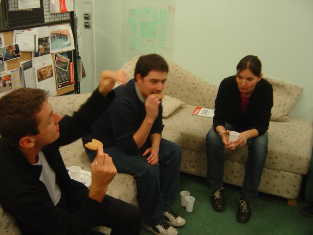 Vincent eating a cooking and raising arm, Vivien eating a cookie and Alex doing a funny face