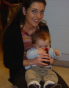Alexis sitting on Coralie's lap and apparently drinking from a red glass (really drooling in it)