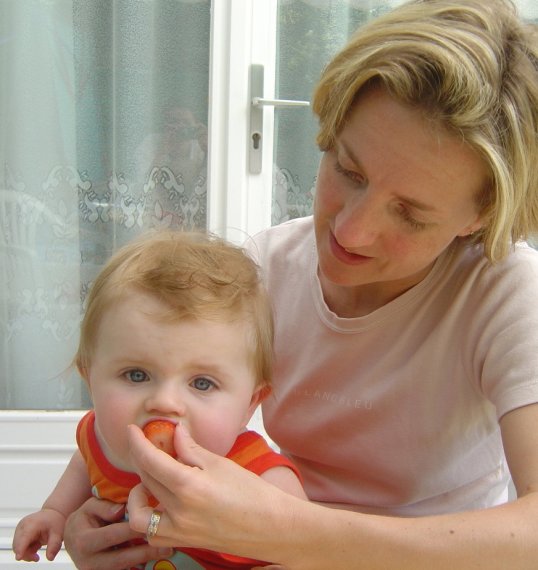 Christine feeding Alexis a strawberry