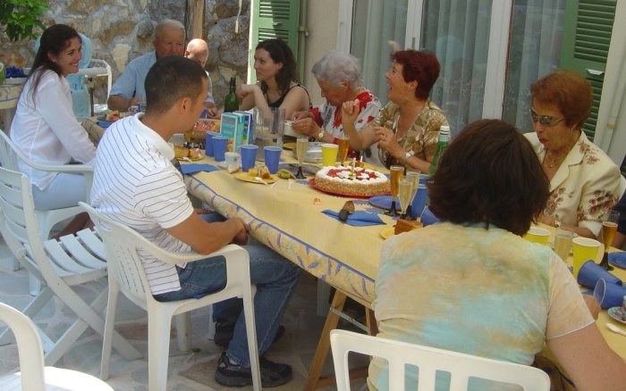 Birthday cake surrounded by plenty of people
