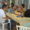 Birthday cake surrounded by plenty of people