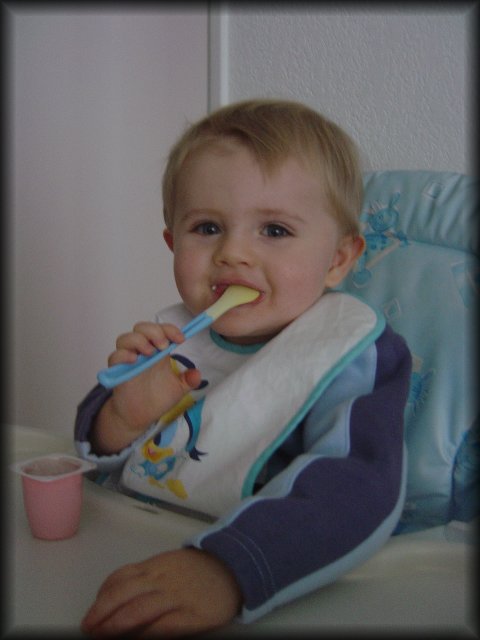 Alexis smiling and eating his yoghurt