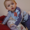 Alexis bending on the armrest of the couch, a quizzical look on his face