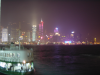 Vague ferry in foreground, lit building behind the dark water