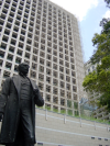 Bronze statue in front of a huge building being renovated