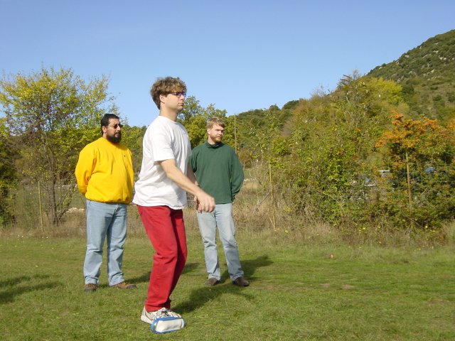 Ian in a peculiar position prior to throwing the boule, Simon and Ted watching 