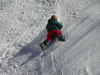 Petit garcon glissant a plat ventre dans la neige