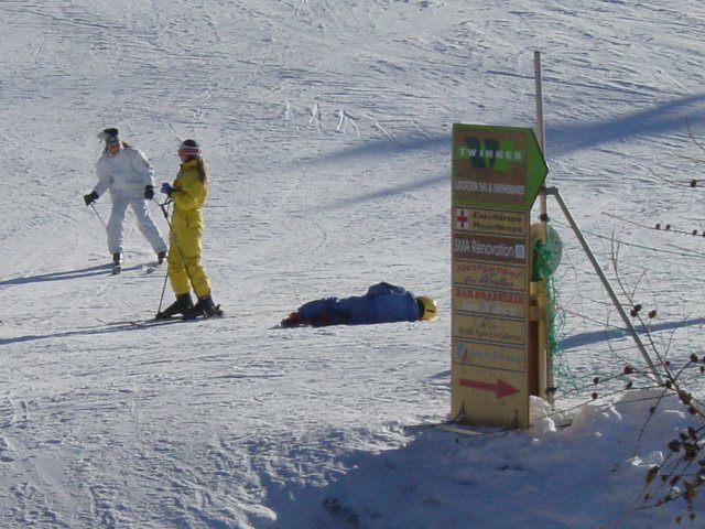 Deux enfants a ski, un enfant couche dans la neige