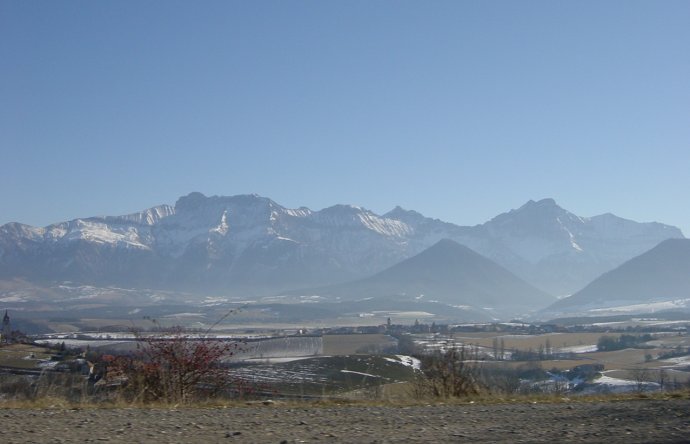Plaine, brume, montagnes enneigees