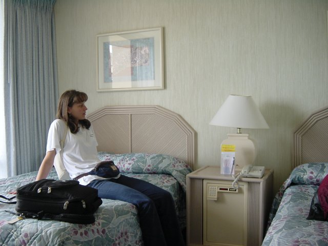 Caroline sitting on her bed in the room of the Ohana Waikiki Tower hotel
