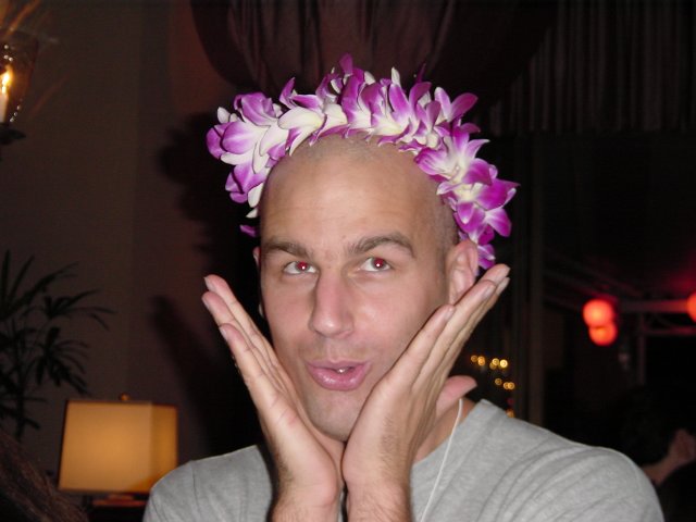 Dean with a lei on his head, both palms on his cheeks