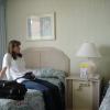 Caroline sitting on her bed in the room of the Ohana Waikiki Tower hotel