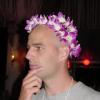 Dean with a lei on his head, holding his chin