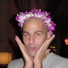 Dean with a lei on his head, both palms on his cheeks