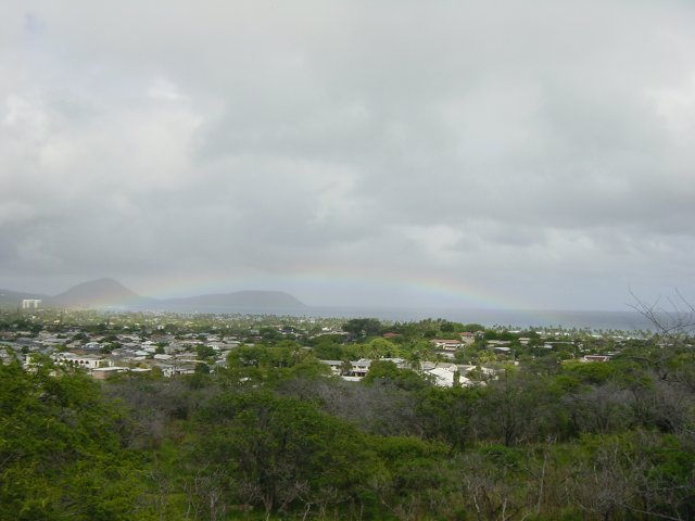 Long and flat rainbow on the ocean, view from the foot of Diamond Head