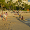 Man bent to take a picture of three children on the beach