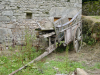 Charrette remplie de planches entre la maison et le puits