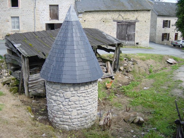Vue du chemin sur le puits et l'abri a bois