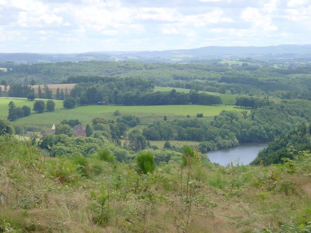 Chateau de Peyrusse a gauche, bras du Thaurion a droite, prairies et forets dans le fond