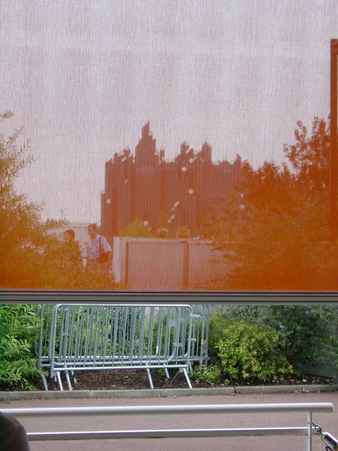 Dans la file d'attente 'Couleurs Bresil': vue a travers un filtre orange sur le pavillon 'Le tapis magique'