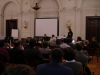 View from the back of the room of the attendees, Daniel, Marie and Eva at the front