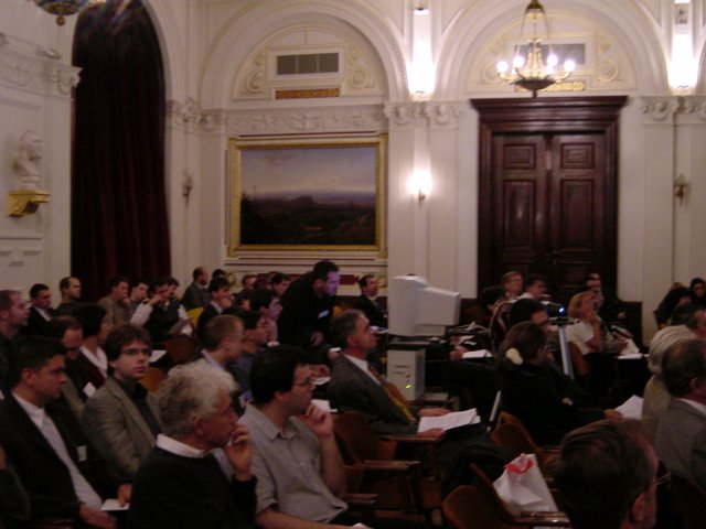 Daniel in front of the main computer in the middle of a well filled up room