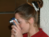 Coralie l'oeil dans le viseur de son appareil photo numerique