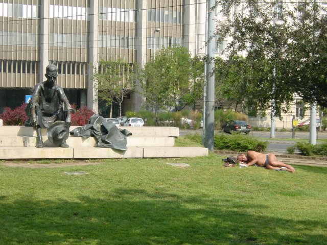 Statue of sitting bronze man and sleeping flesh man