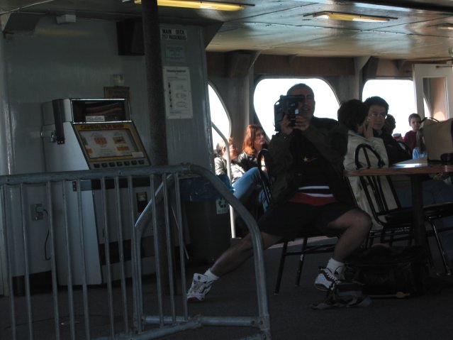 Man holding a camcorder and being in a strange posture