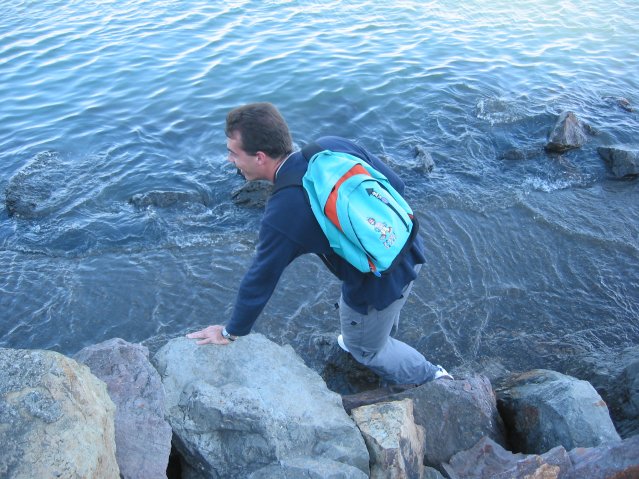 Stephane with his feet in the water on the flooded promenade