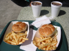 Two hamburgers, fries and cokes