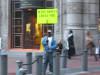 Man holding a "Jesus Christ loves you" post