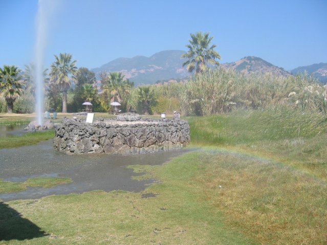 Rainbow on foreground and geyser