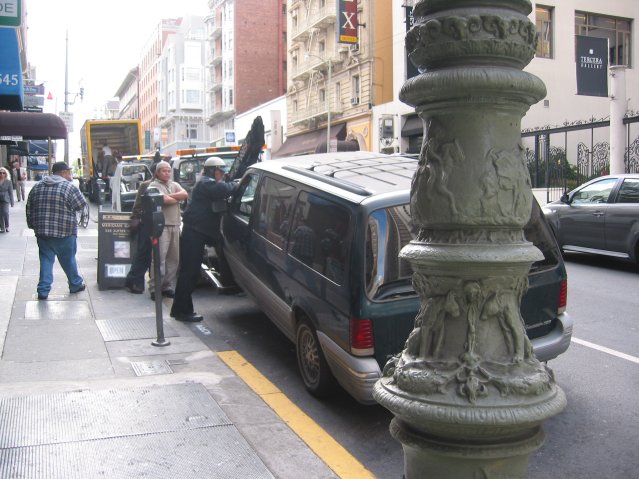 Van being towed away and police officer placing a ticket