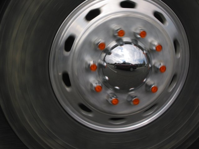 Reflection of our car in the shiny wheel of a truck