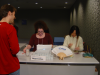 Amy and Saeko setting up the registration desk under Karl's scrutiny