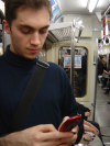 Olivier fiddling with his mobile phone in the train
