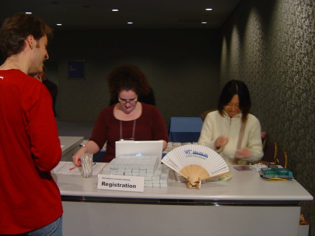 Amy and Saeko setting up the registration desk under Karl's scrutiny