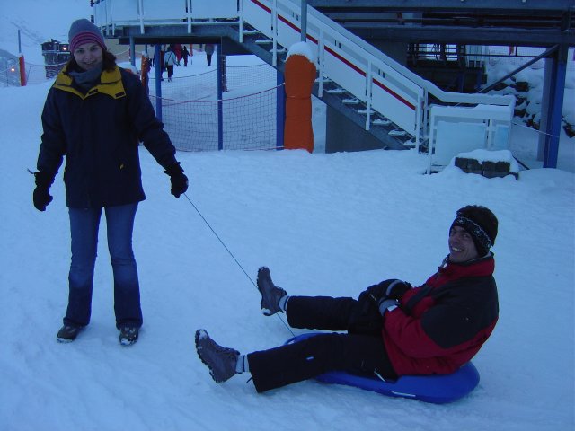 Alex tient la luge ou Steph est assis