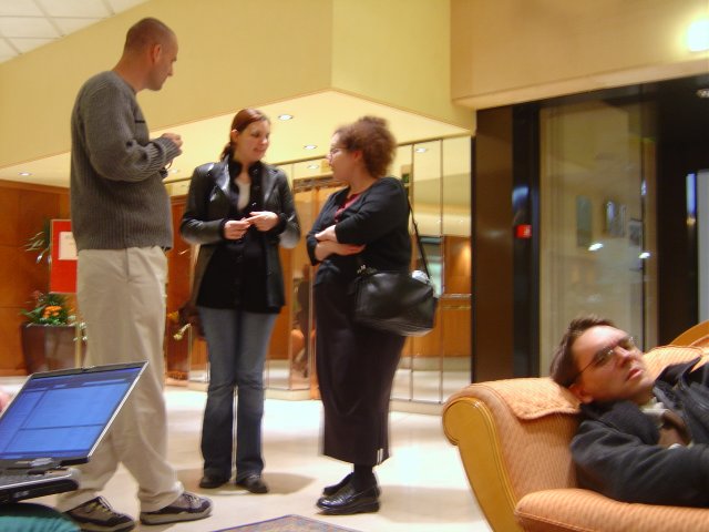 Dean, Alex, Amy standing in the lobby, Max still lying in the armchair