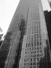 Two tall buildings reflected in a taller one