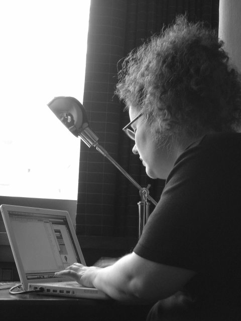 Amy facing her computer and a lamp on which she's reflected