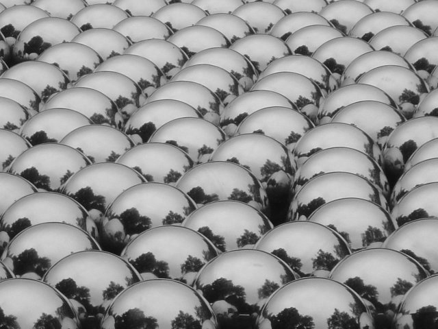 Metallic balls with reflections of the park and buildings