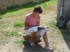 Evelyne assise sur une pierre au soleil lit son livre