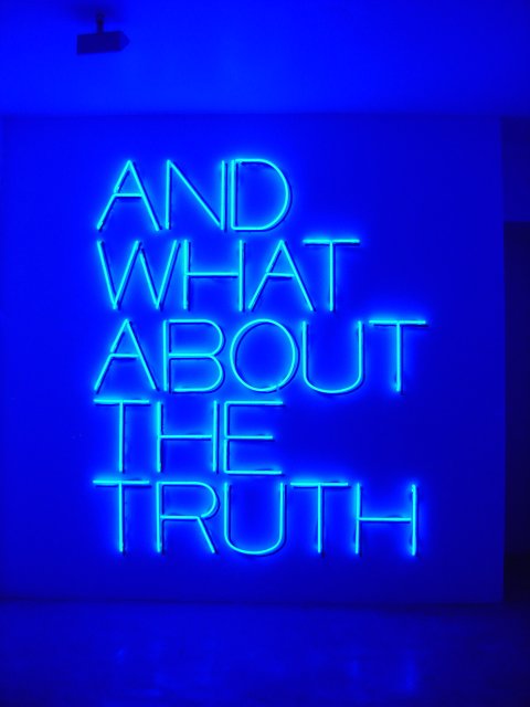 Art expo "And what about the truth" in blue neon letters 
