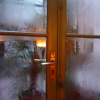 Steam on windows, potted plants outside