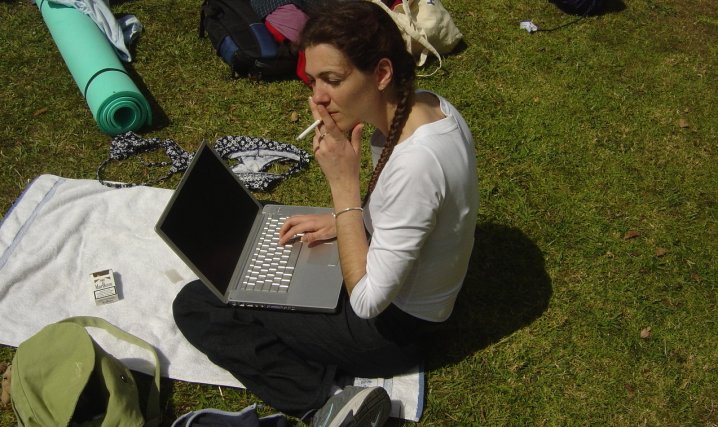 Coralie smoking and typing, campsite, Matamata