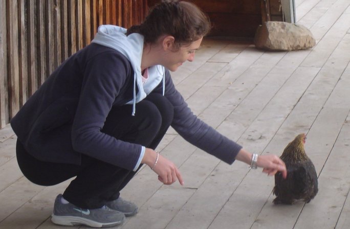 Coralie petting a hen