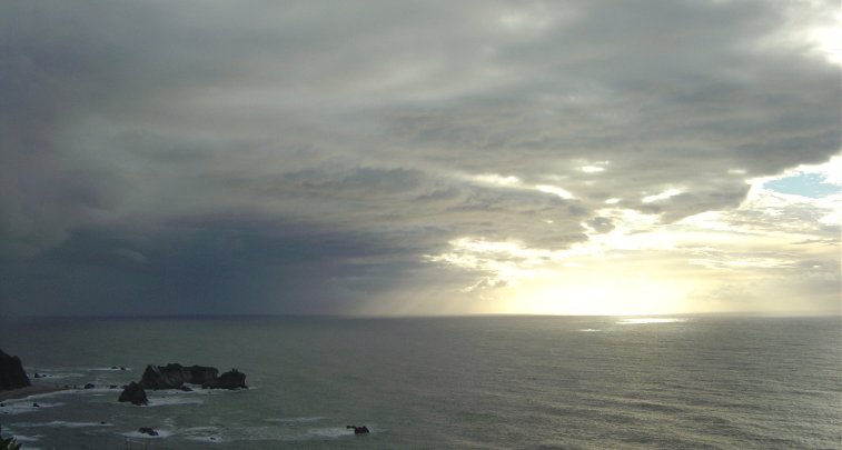 Sun beams found a way through dark clouds over the Tasman Sea