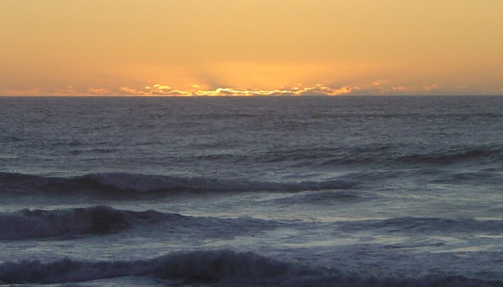 Orange sunset over a grey indigo Tasman Sea